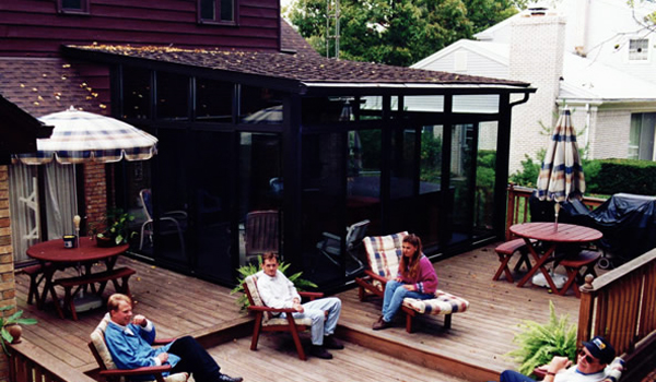 large wooden deck with patio enclosure