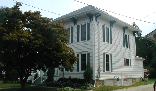 white house with white railing and green shutters