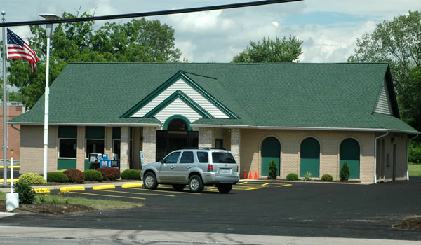 building with white siding and green roof